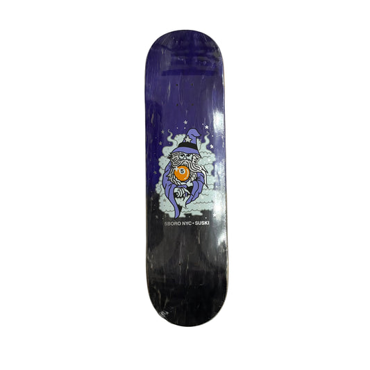 Skateboard deck with a wizard holding a 5ball design on a white surface