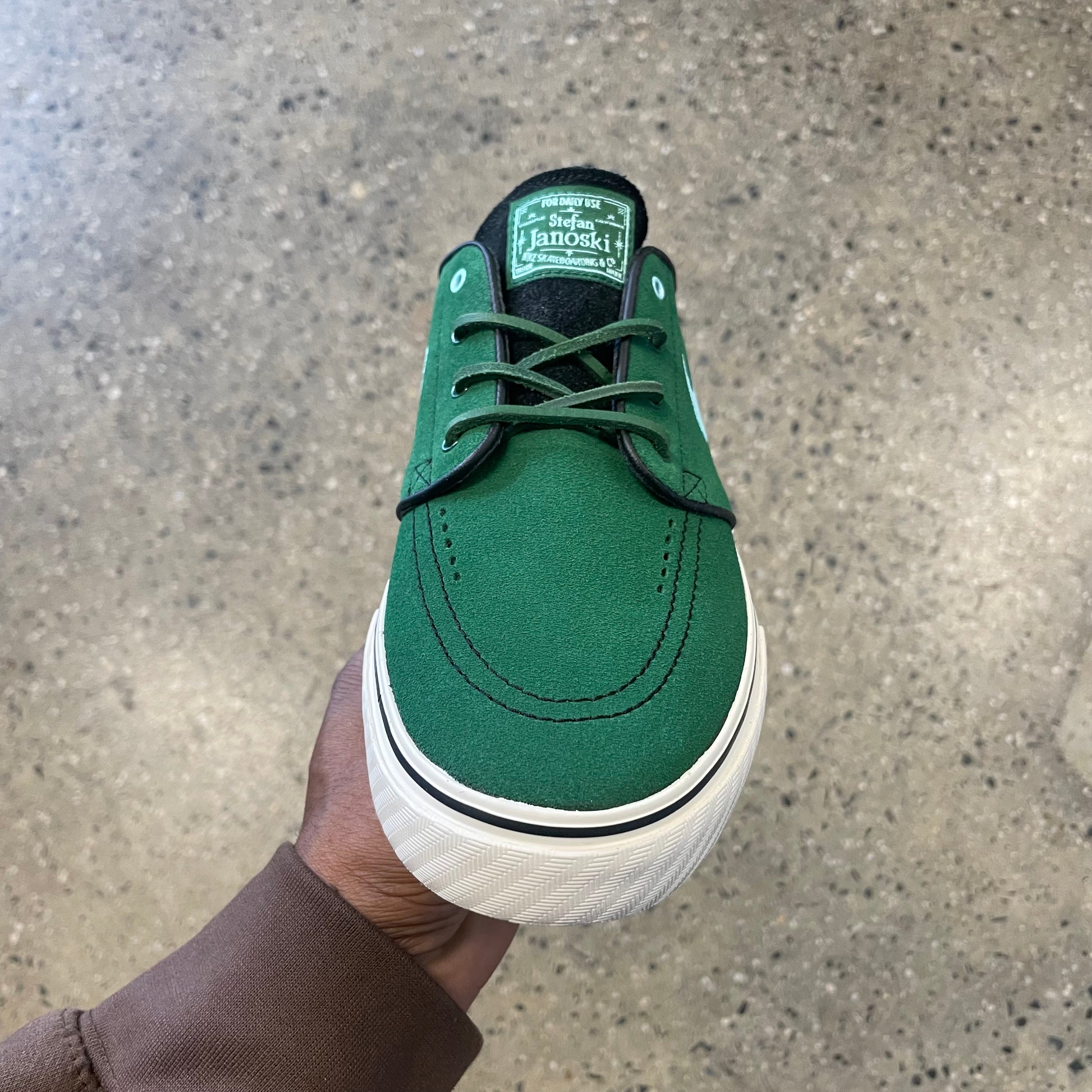 top down view of green suede shoe, white sole