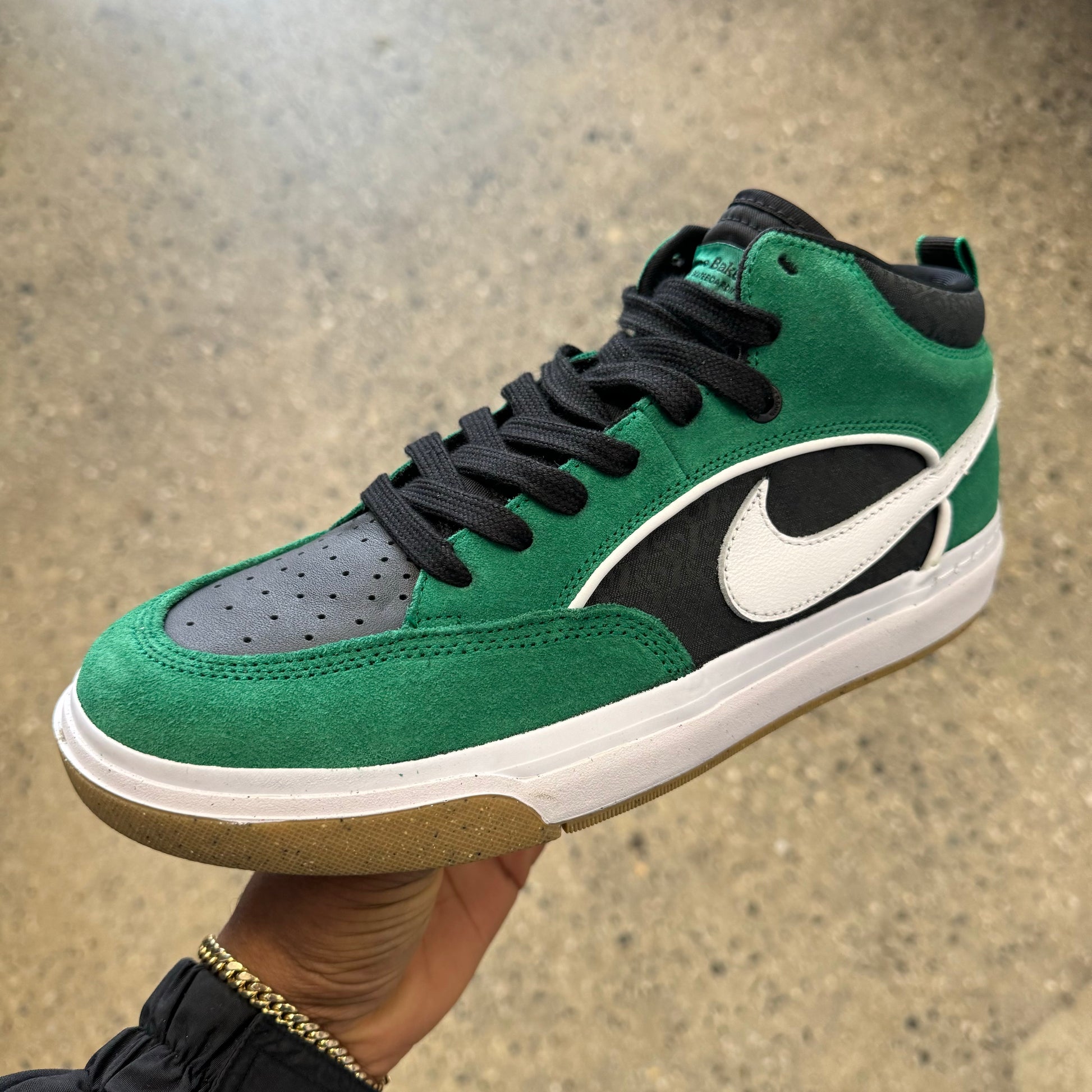 green, black, and white sneaker with white and brown sole