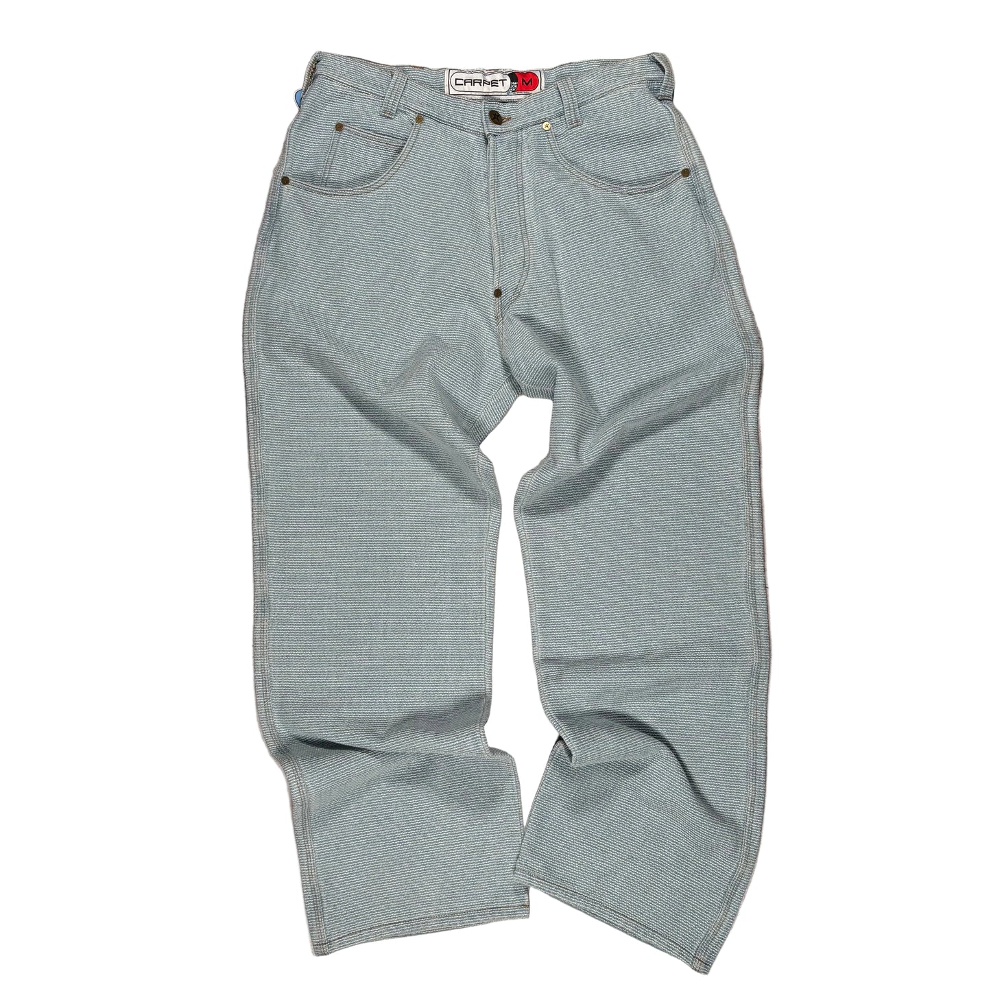 Light blue stitched jeans with a brand label on a white surface