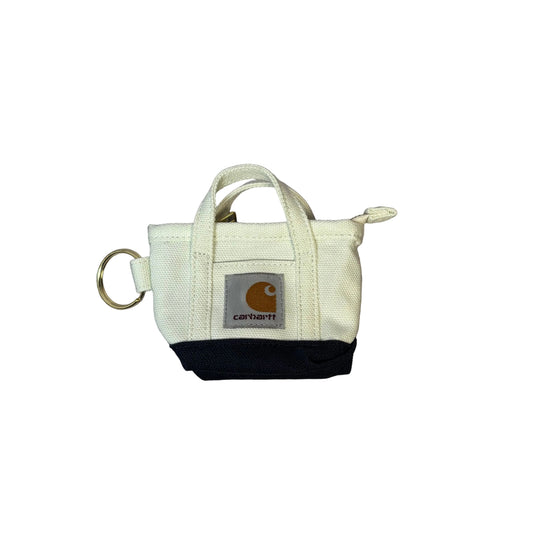Small white and black bag keychain, with Carhartt logo on a white surface