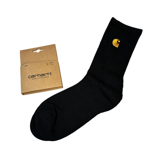 Black sock with yellow logo and Carhartt packaging on a white surface