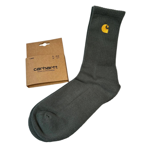 olive green sock with Carhartt logo next to a brown Carhartt packaging box on a white background