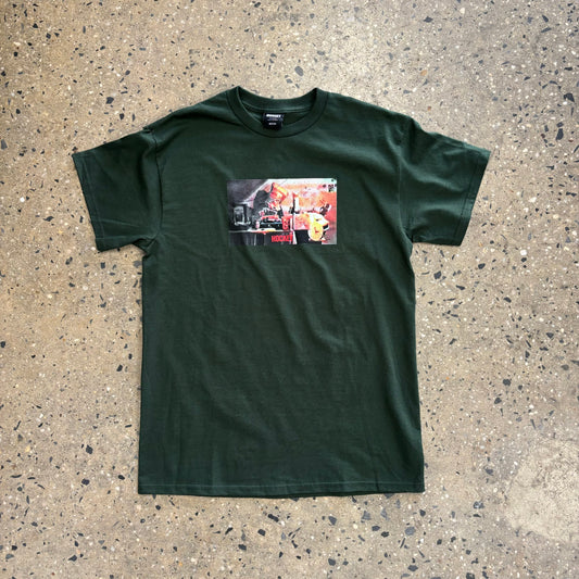 Dark Green t-shirt with center chest graphic of person wearing paper bag on their head DJing