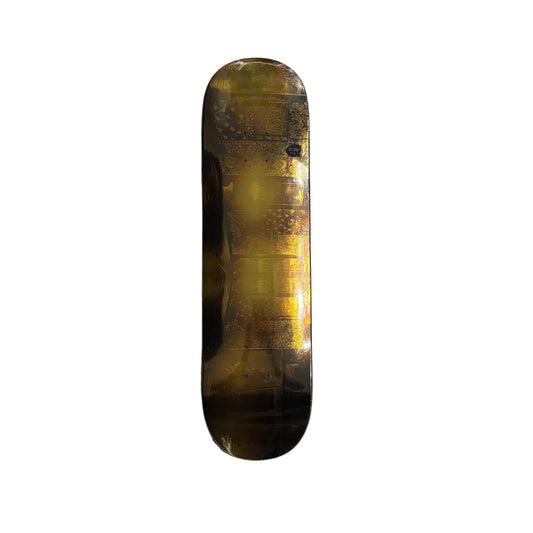 Skateboard deck with a reflective gold surface on a white background