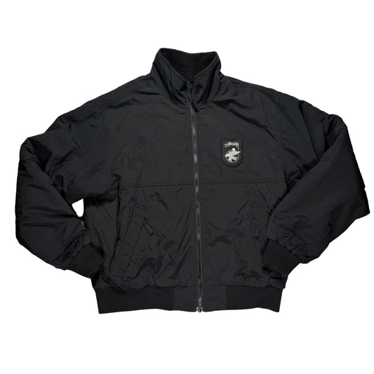 Black jacket with a logo on a gray surface