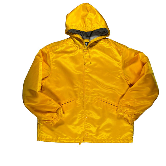 Yellow stussy coaches jacket on a white surface