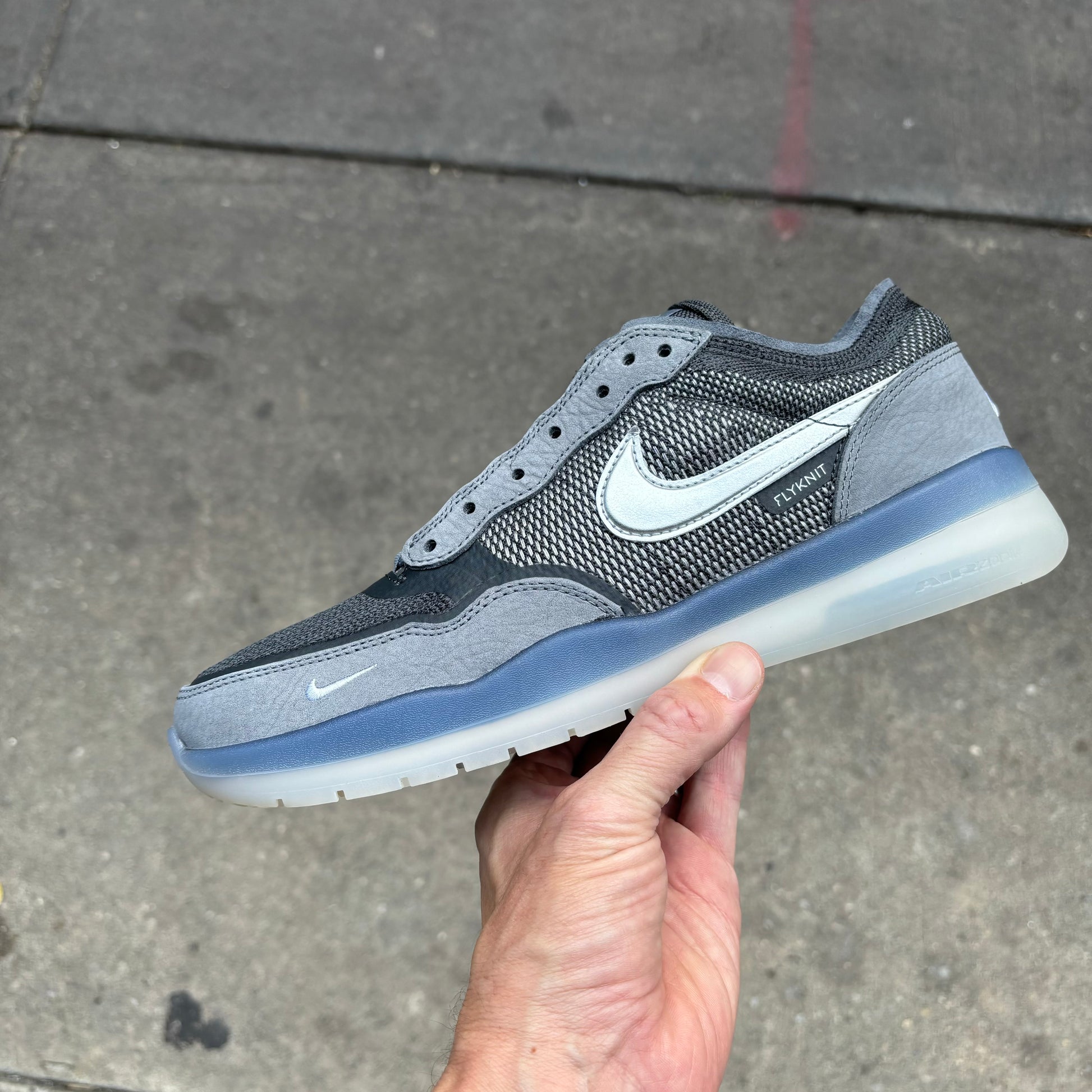 Side view of grey suede and mesh sneaker with clear sole