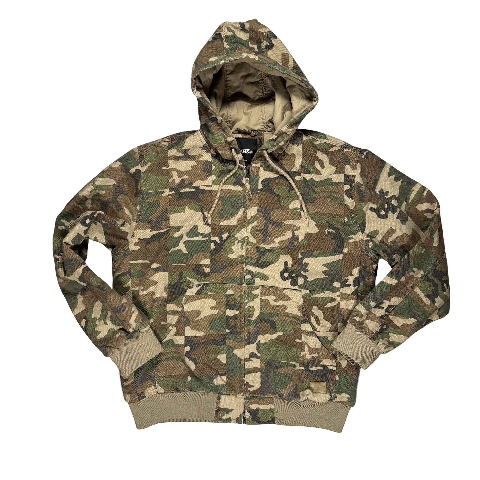 A camouflage zip-up hooded jacket with a kangaroo pocket, laid flat on a textured white surface. The jacket features a classic woodland camo pattern in green, brown, tan, and black, with solid olive green ribbed cuffs and hem.