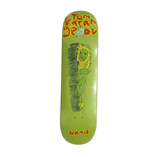 Skateboard deck with a green dragon illustration and 'Tom K' branding on a white surface.