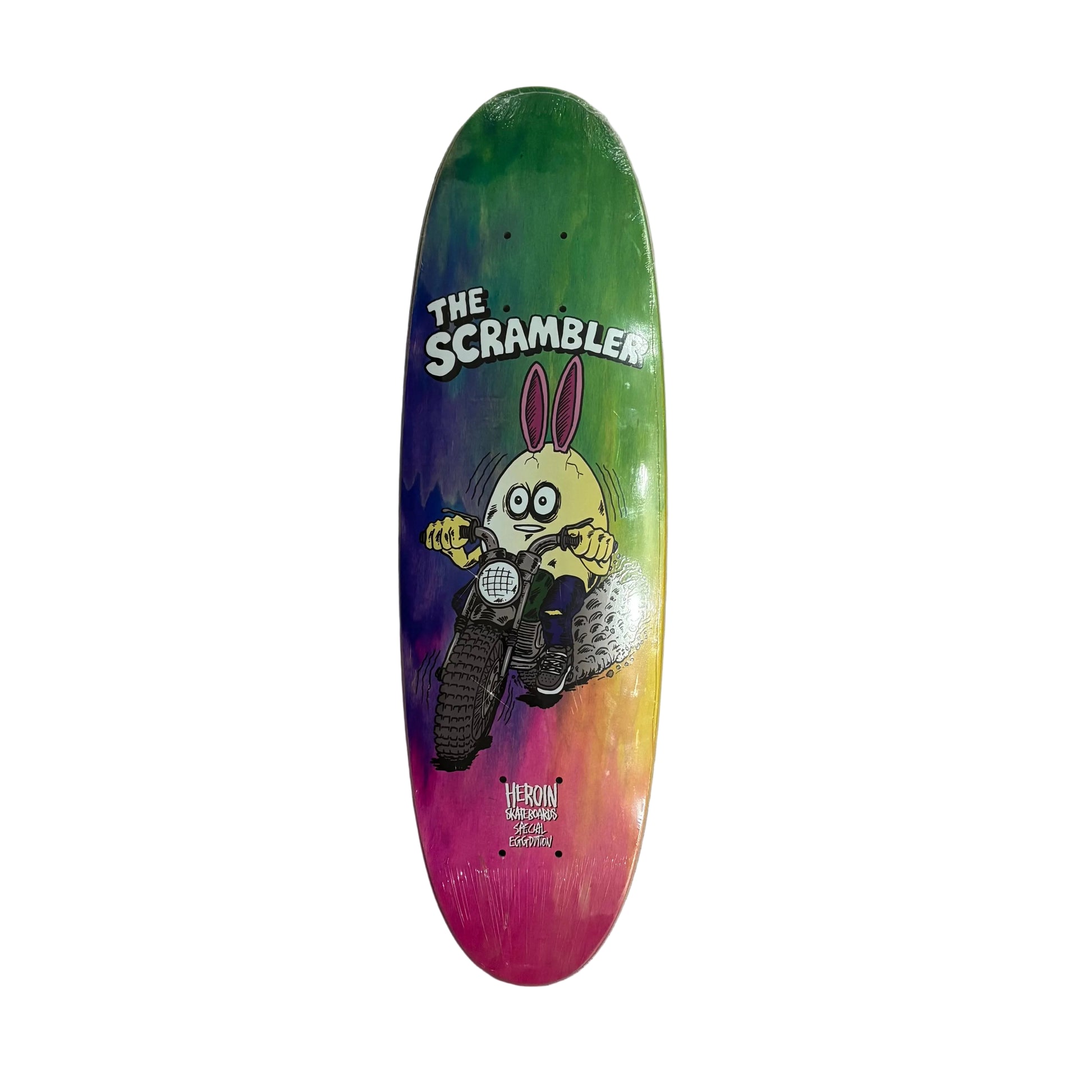 Colorful skateboard deck with a cartoon character and 'The Scrambler' branding on a white surface.