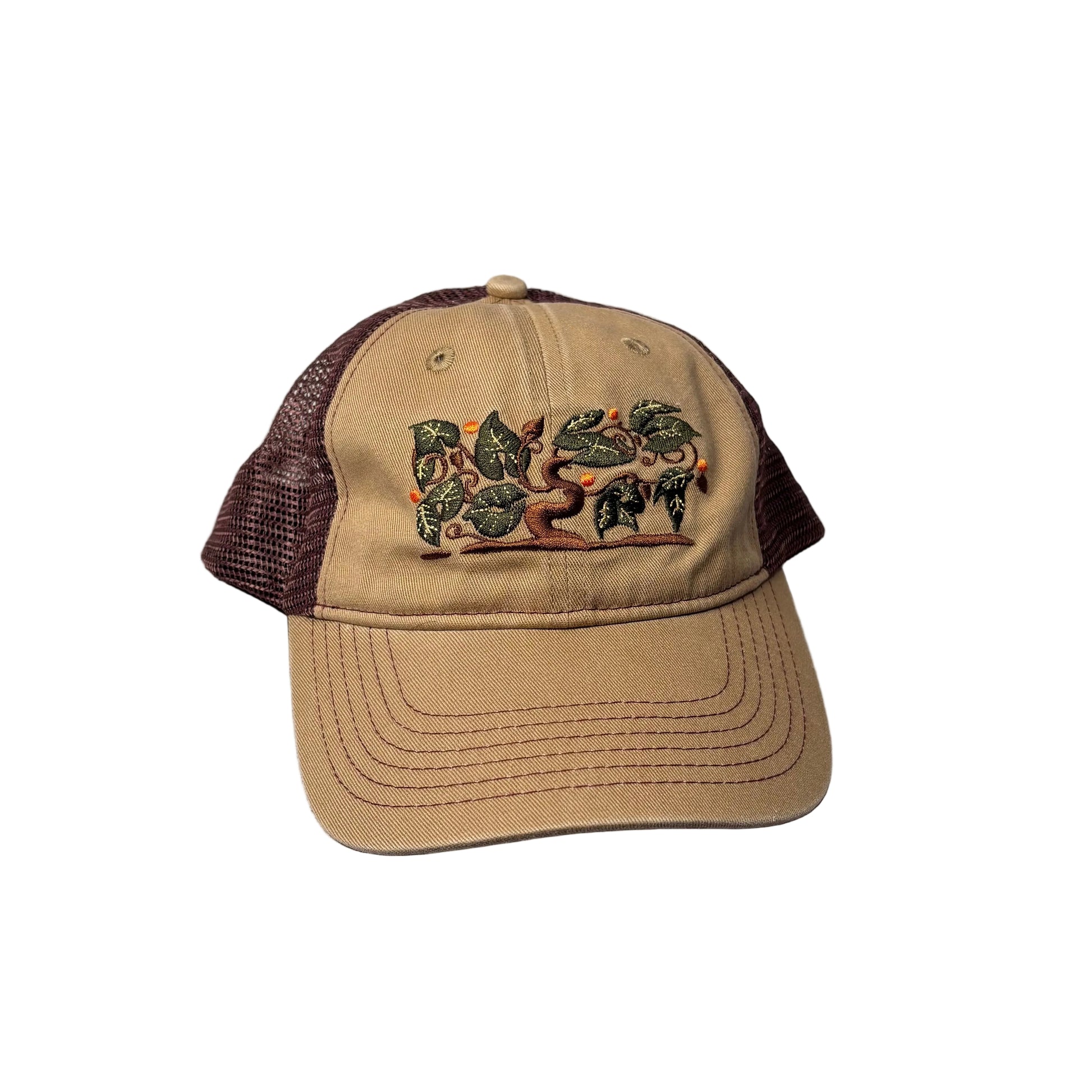 Tan and brown cap with embroidered design on a white background