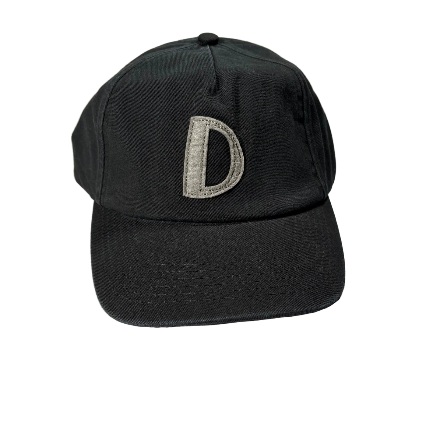 Black cap with a letter 'D' on a white surface