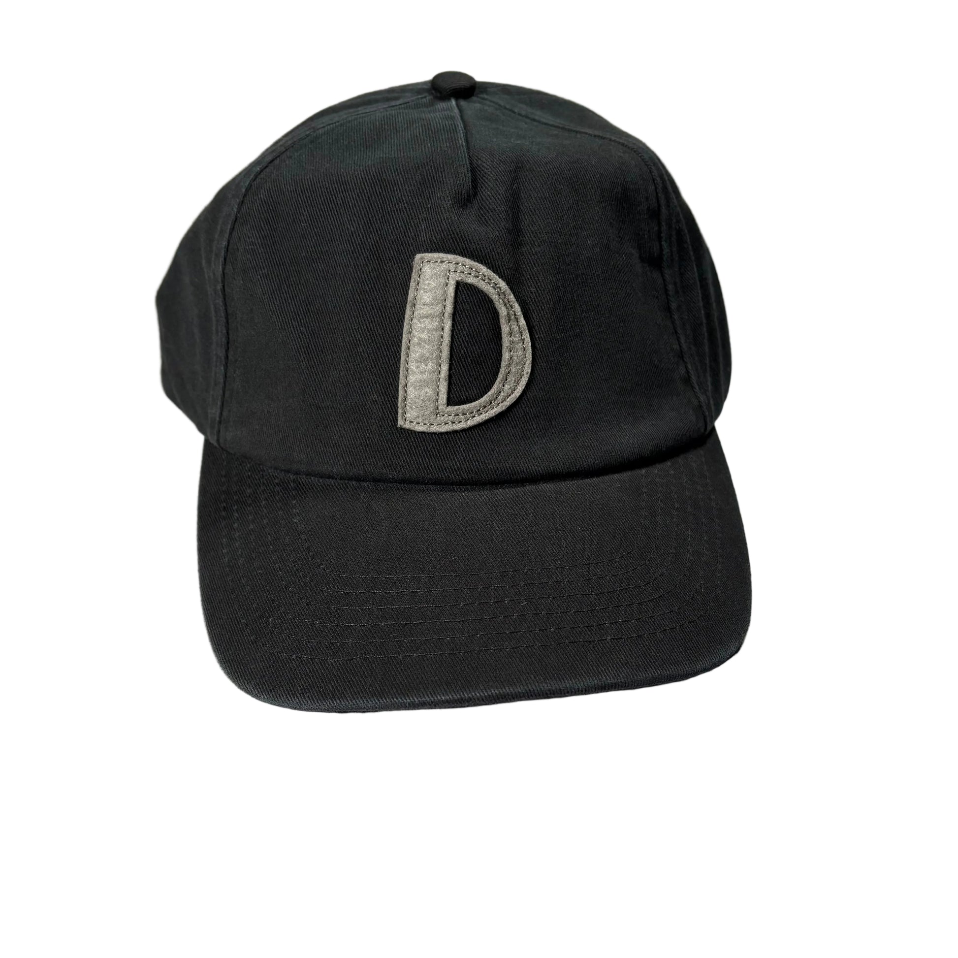 Black cap with a letter 'D' on a white surface