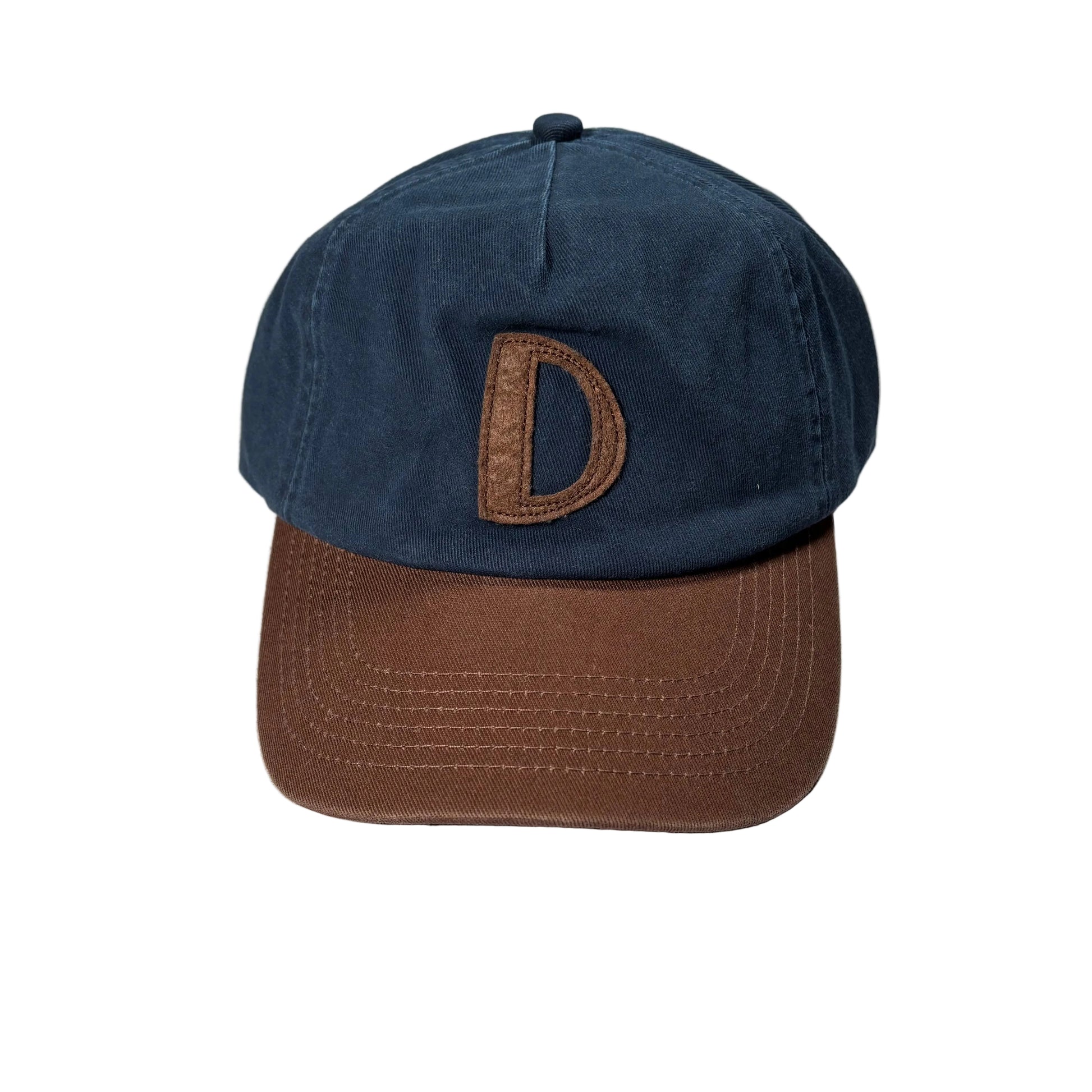 Navy blue and brown cap with a 'D' logo on a white surface.