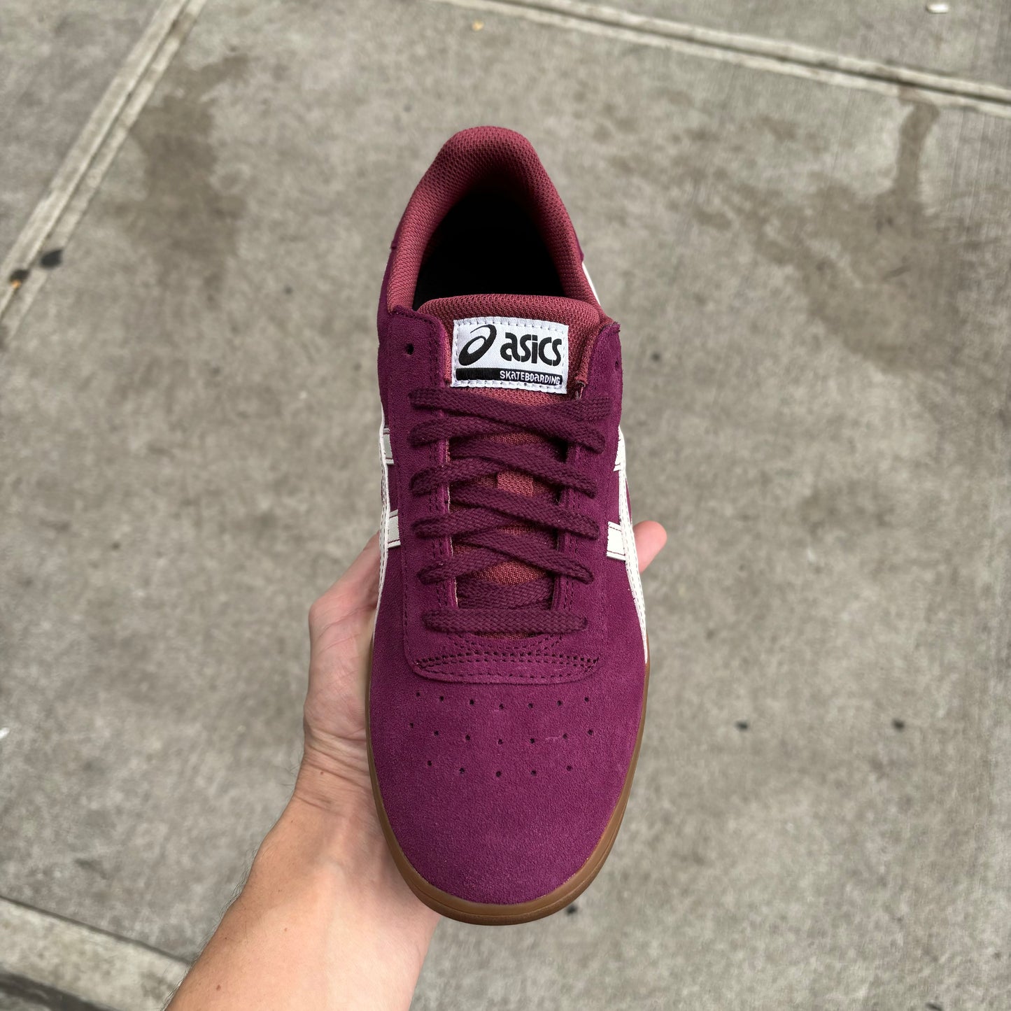 Top down view of burgundy suede skate sneaker with white accents