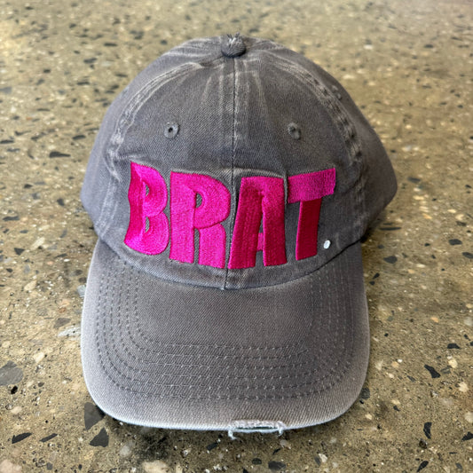 Front view of pink embroidered brat logo on washed denim hat