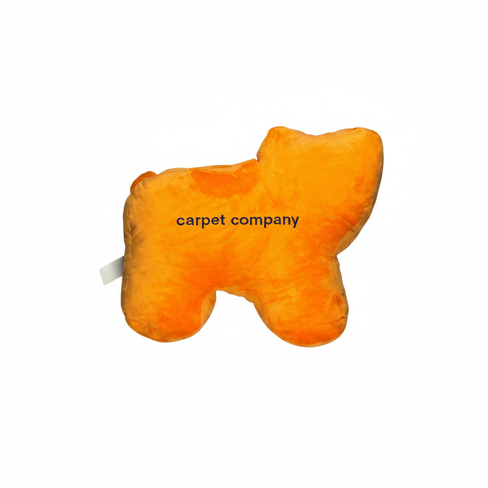 Orange plush toy with 'carpet company' branding on a white surface