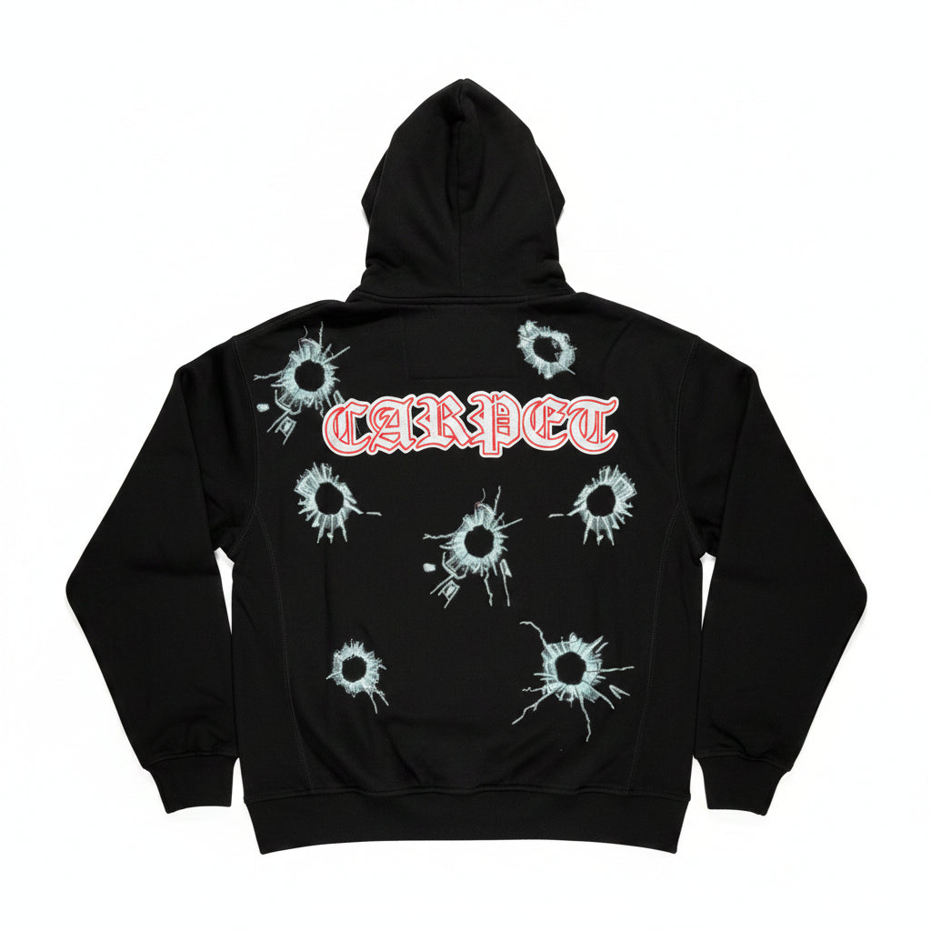 Black hoodie with bullet hole designs and 'CARPET' text on a white surface.
