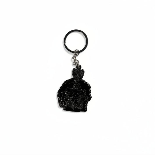 Black keychain with a muscle bound figure on a white background