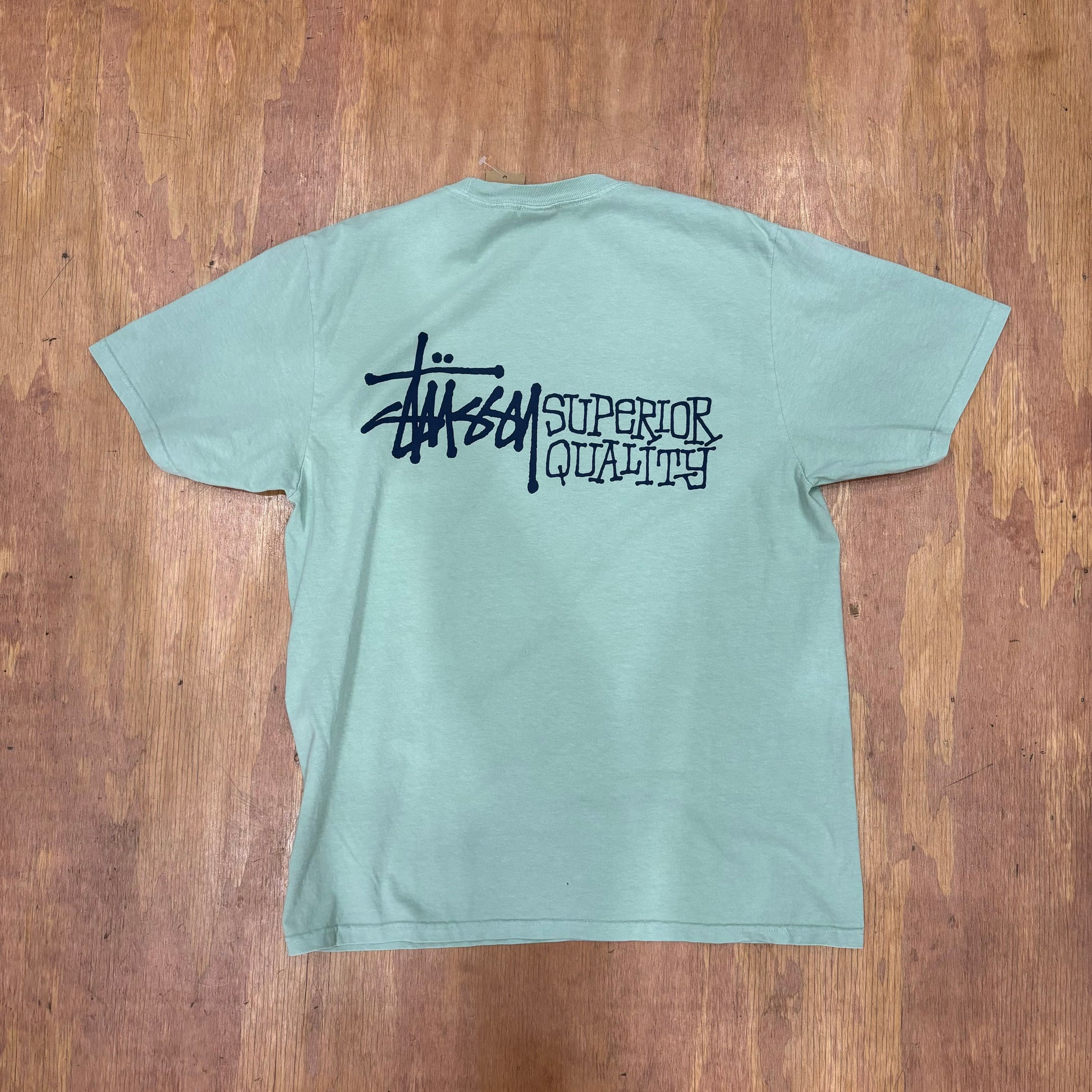 rear view of stussy graphic tee with superior qualirty logo