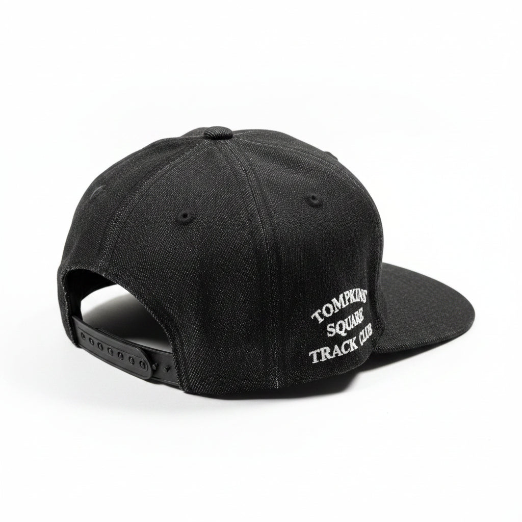 Black cap with 'Tompkins Square Track Club' text on a white surface