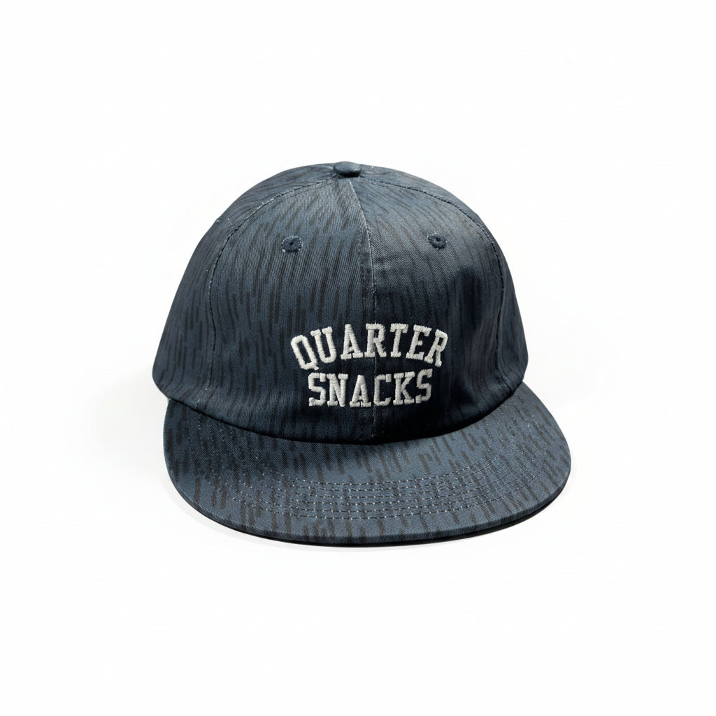 Black cap with 'Quarter Snacks' text on a white surface