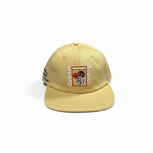 Beige cap with logos on a white surface