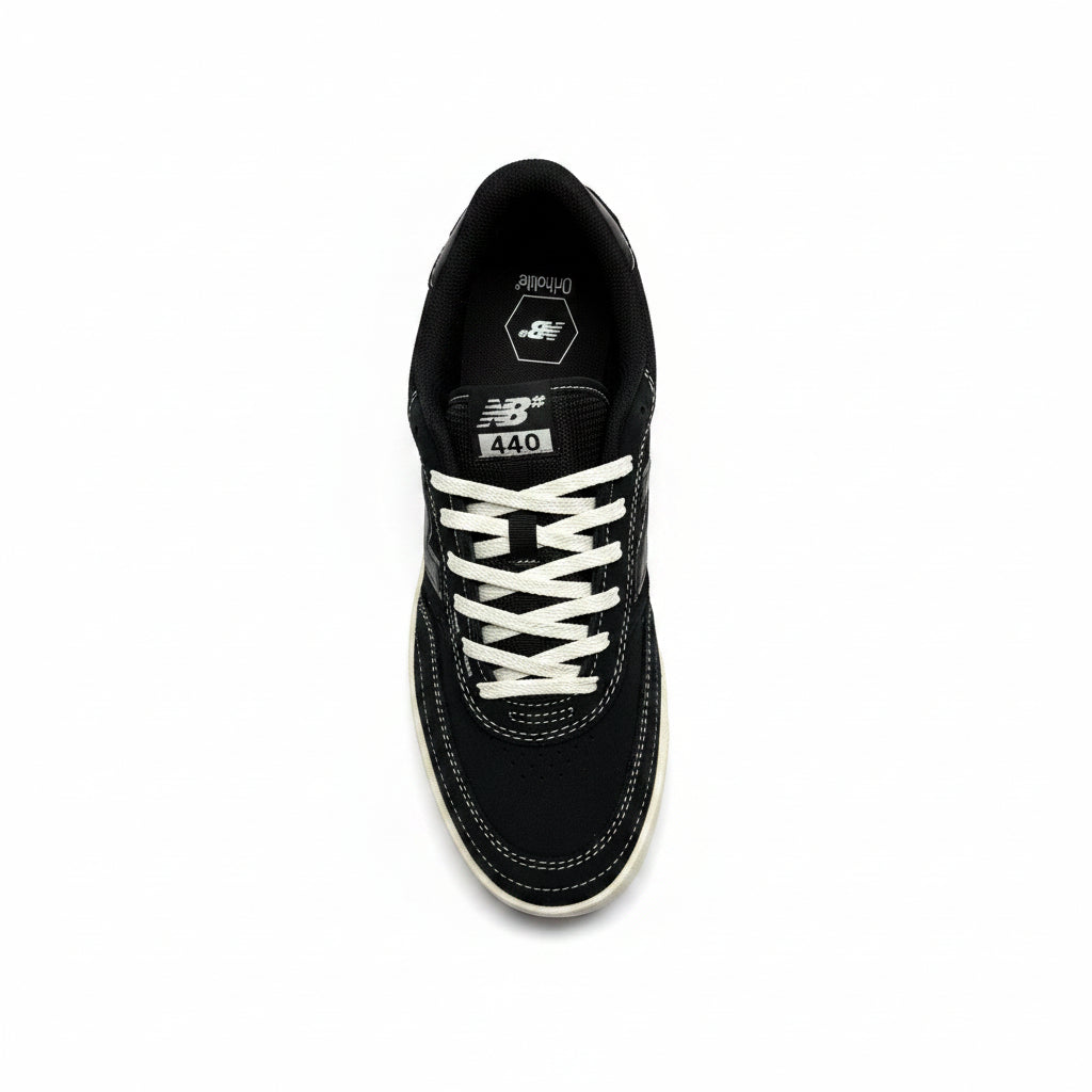 Black sneaker with white laces on a white surface
