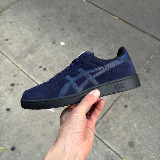 Side view of navy and black suede skate sneaker