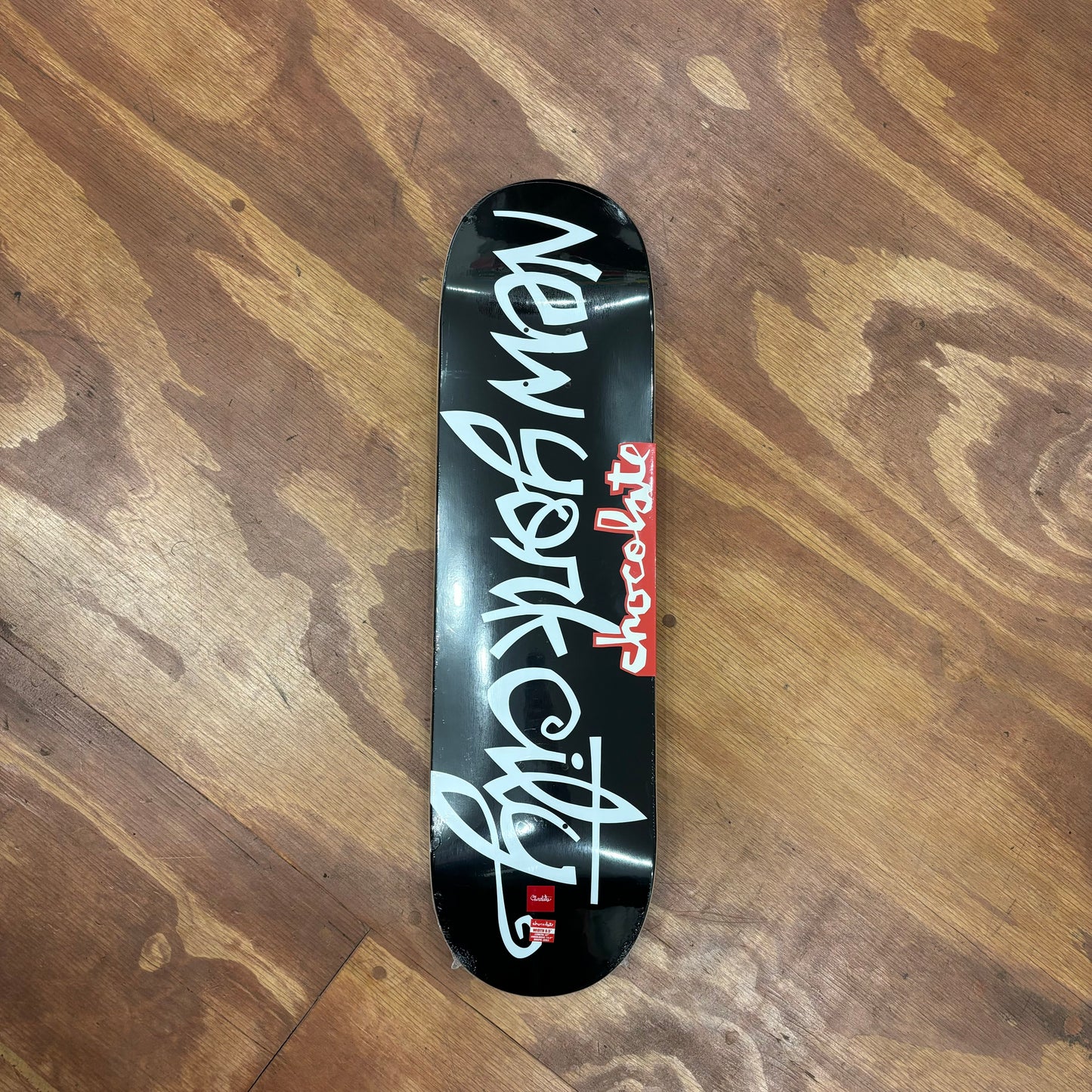 view of black and white skateboard deck with NEW YORK CITY written in hand style cursive text