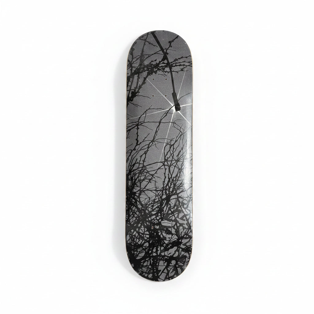 Skateboard deck with black abstract design on a white surface