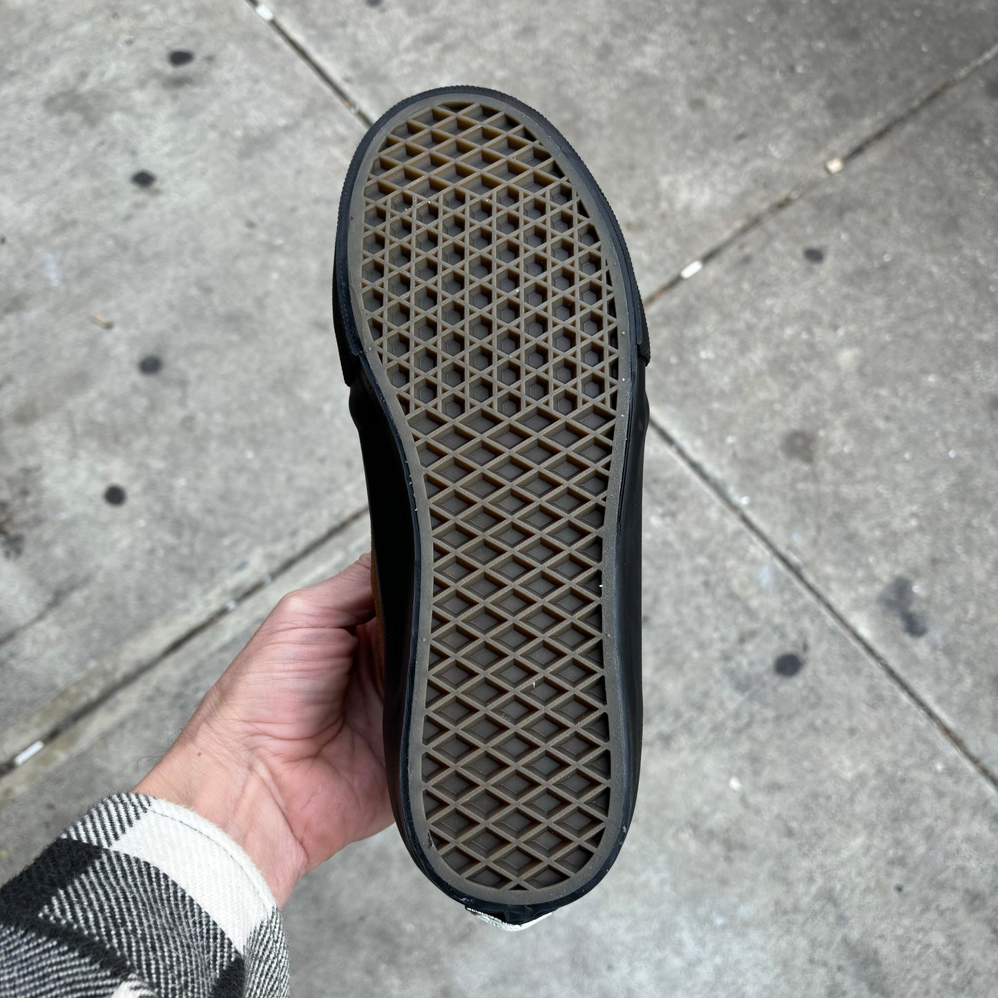 view of gum rubber outsole on brown suede sneaker with black sole