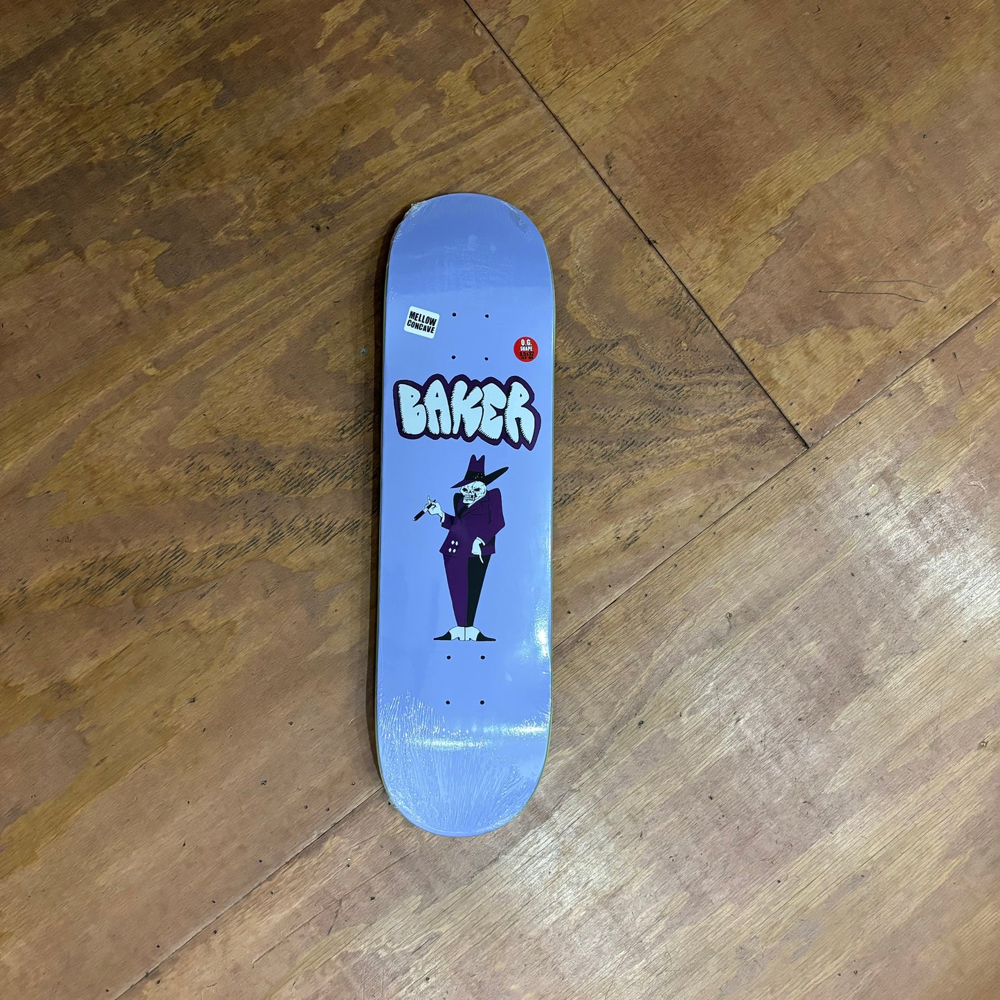 purple skateboard deck with skeleton pimp like man on the middle of the board