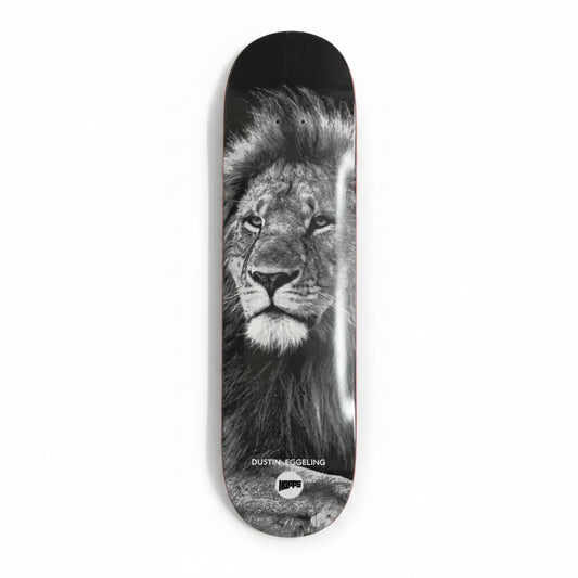 Skateboard deck with a lion's face design on a white surface