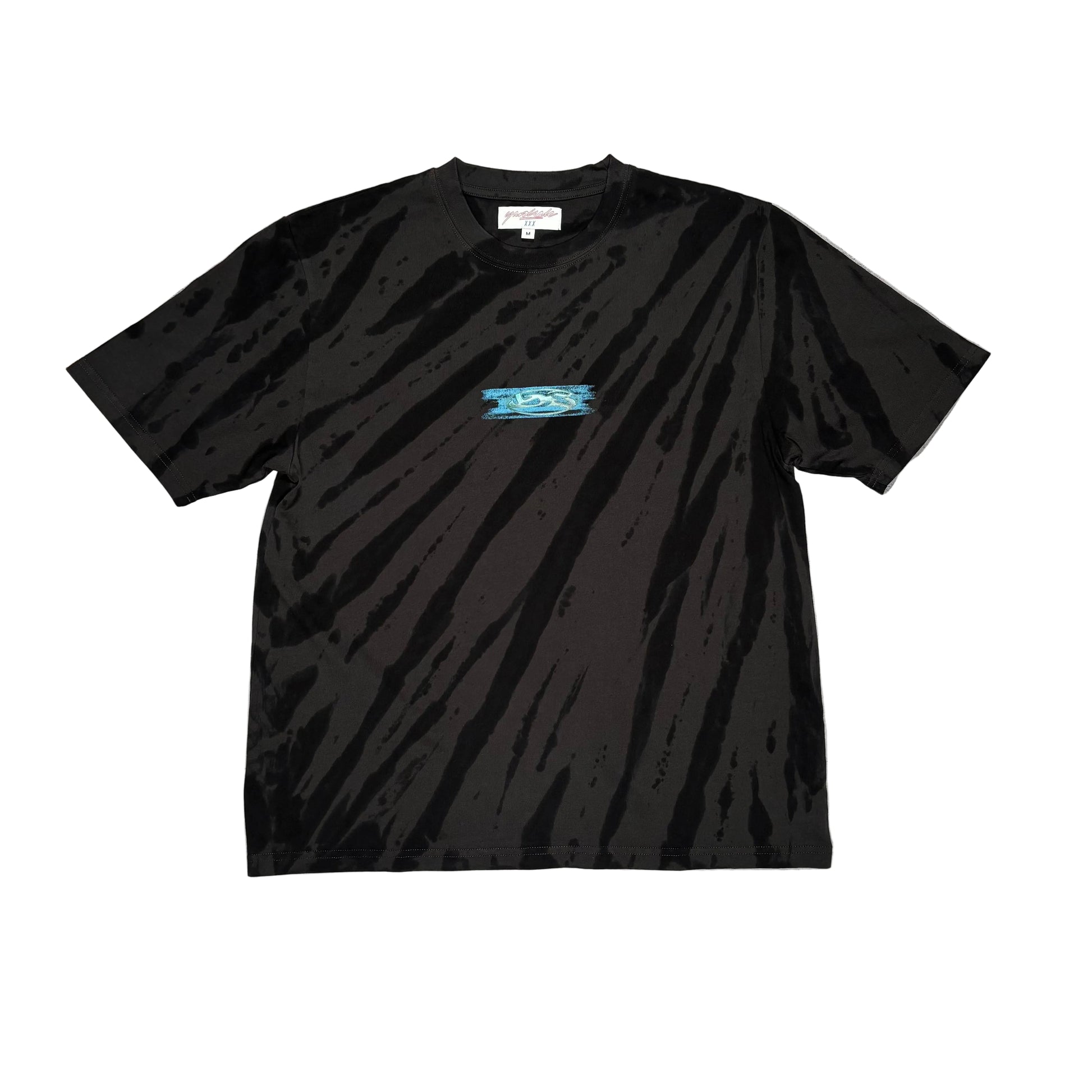 Black t-shirt with light tie dye pattern, and a small center chest logo on a white surface