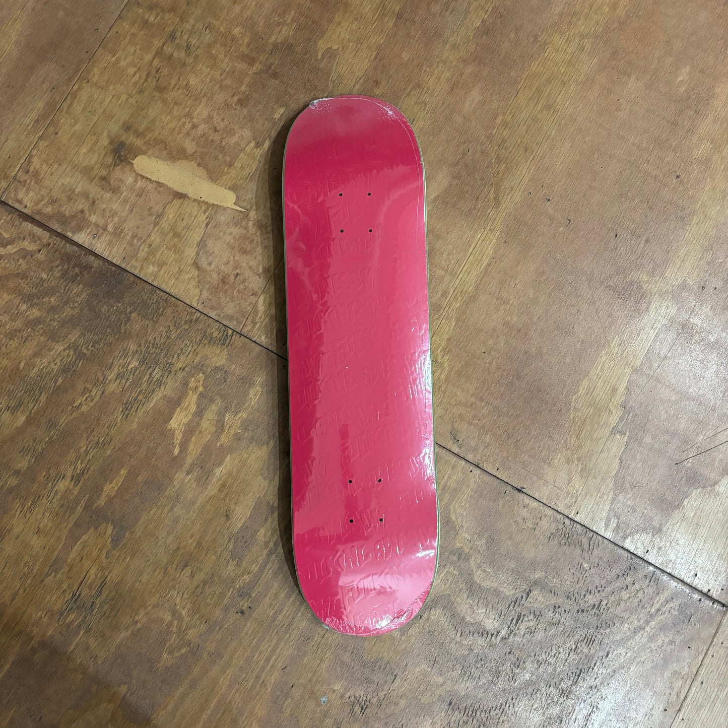 Pink Skateboard deck with FUCKING AWESOME EMBOSSED on deck in repeated pattern