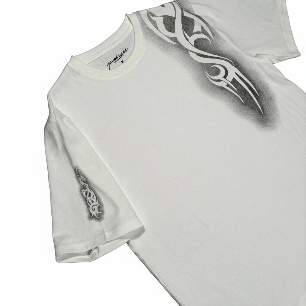 White t-shirt with black tribal design on a white surface