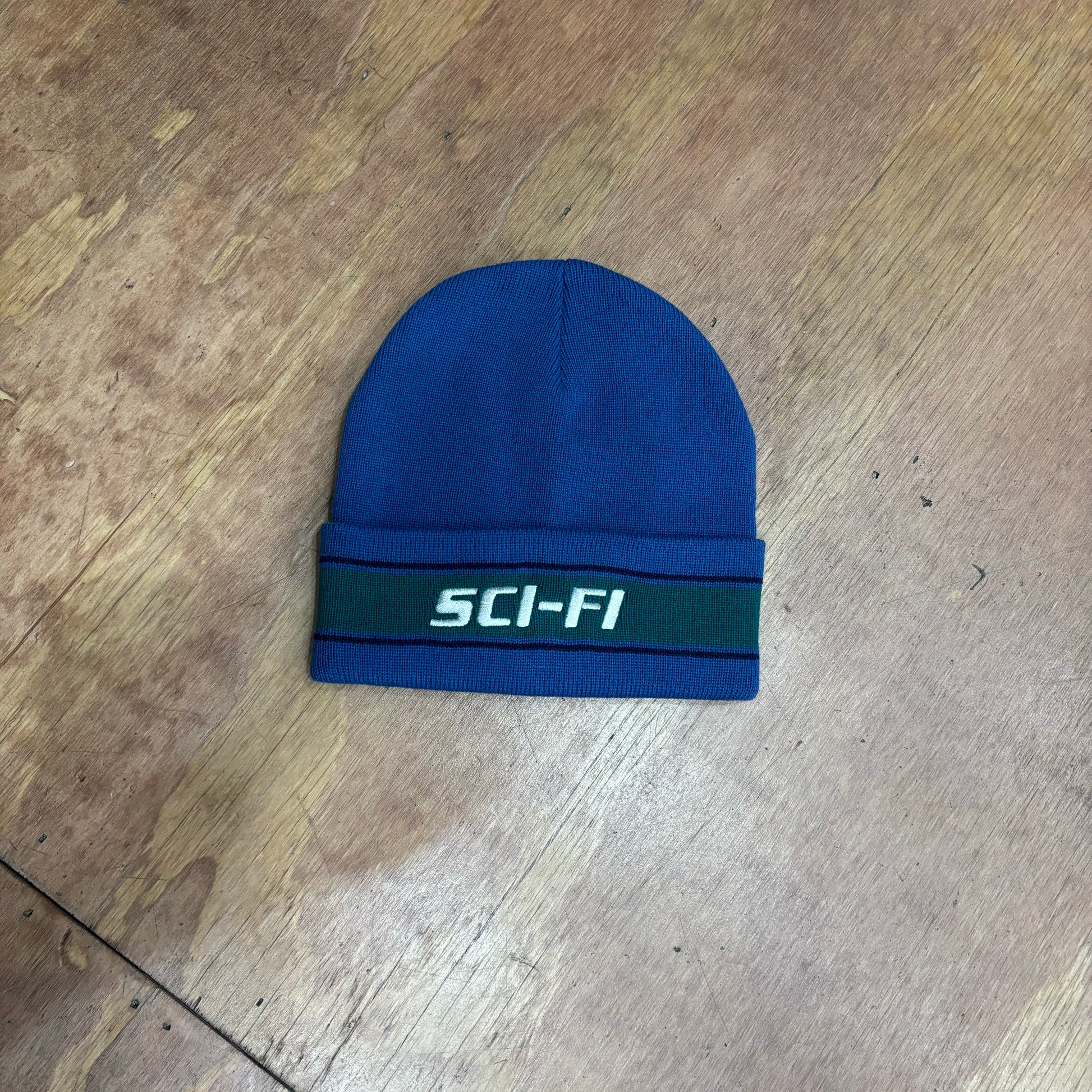 blue and green beanie with SCI FI on fold