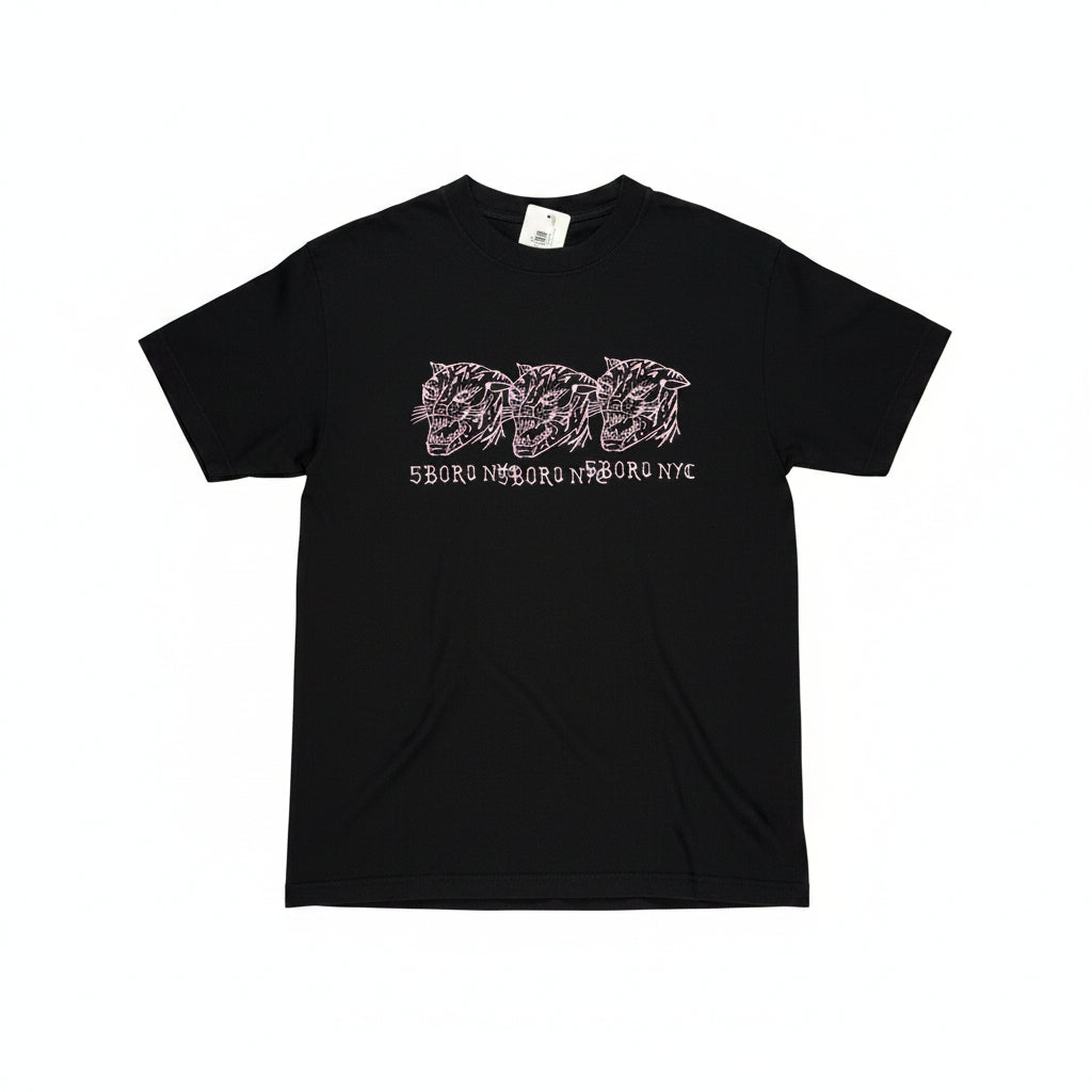 Black t-shirt with three pink hand drawn cat logos on center chest of tee, tee on a white surface