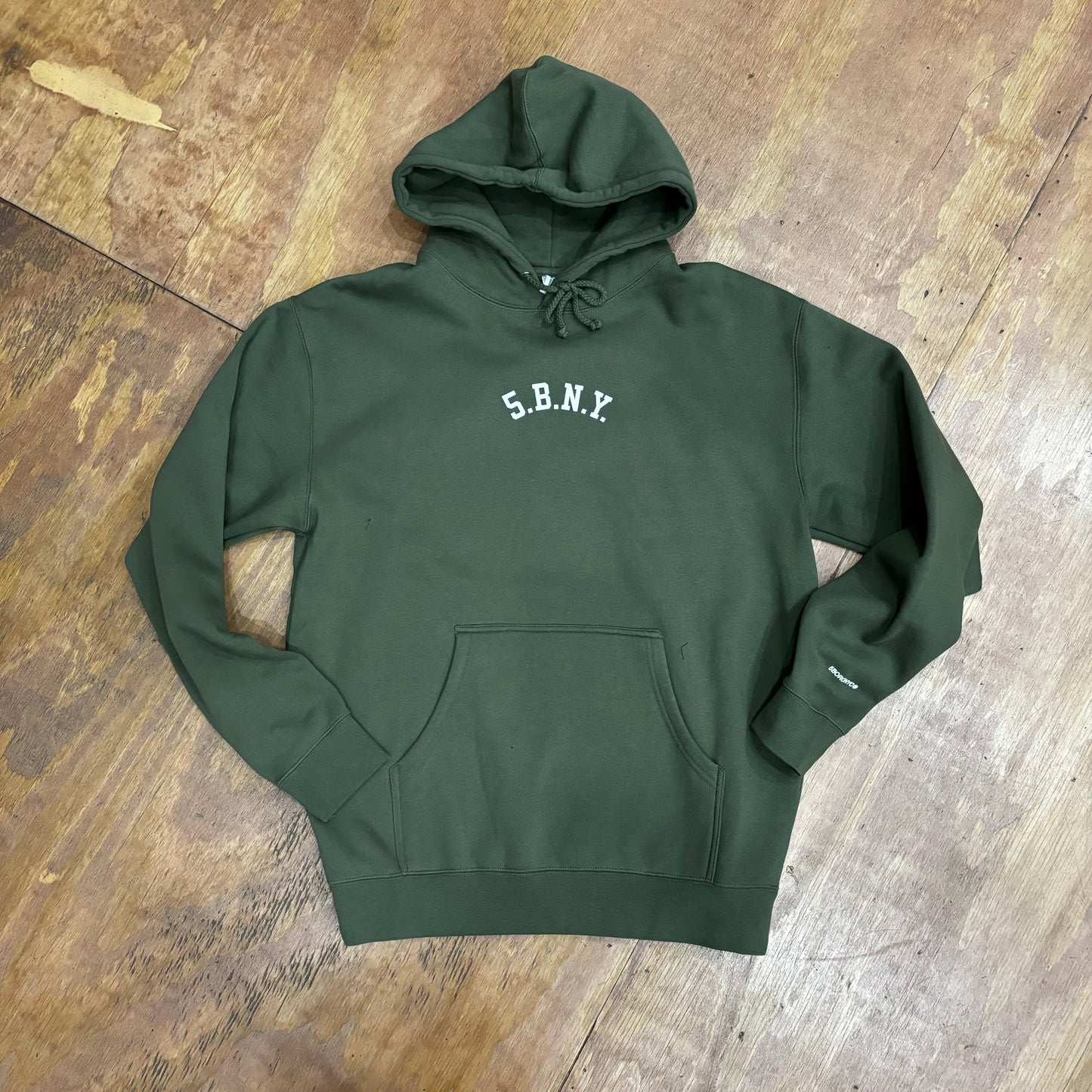 white 5.B.N.Y. arch logo on olive hoodie