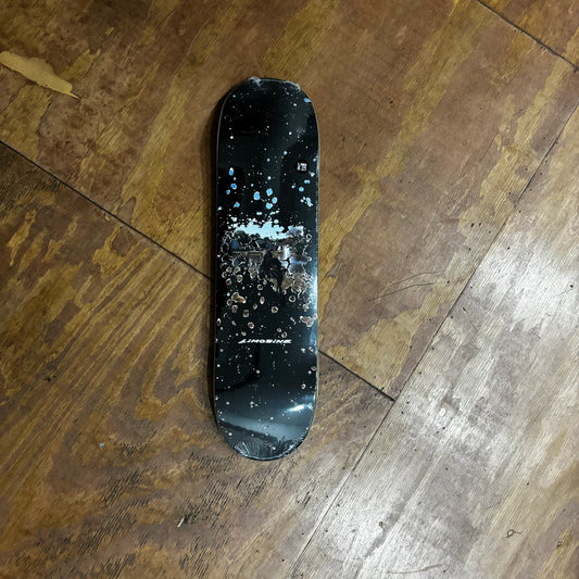 Black skateboard deck with abstract graphic in middle of deck