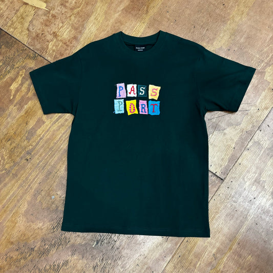 front view of center chest patchwork style graphis reading PASS PORT on forest green t-shirt