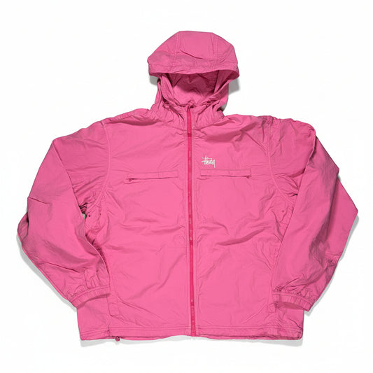 Pink jacket on a white surface with a visible stussy brand logo.