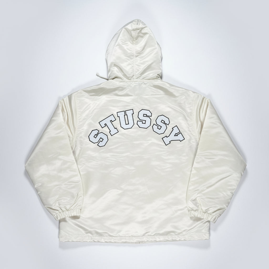 Light-colored jacket with 'Stussy' branding on a white surface