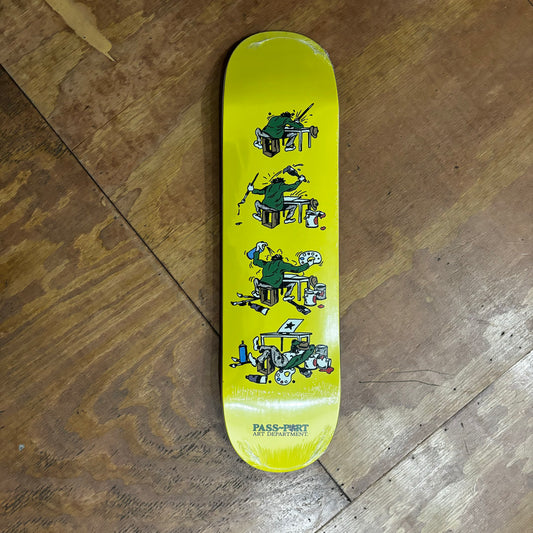 yellow skateboard deck with four images of a man furiously working in his studio desk on some artwork