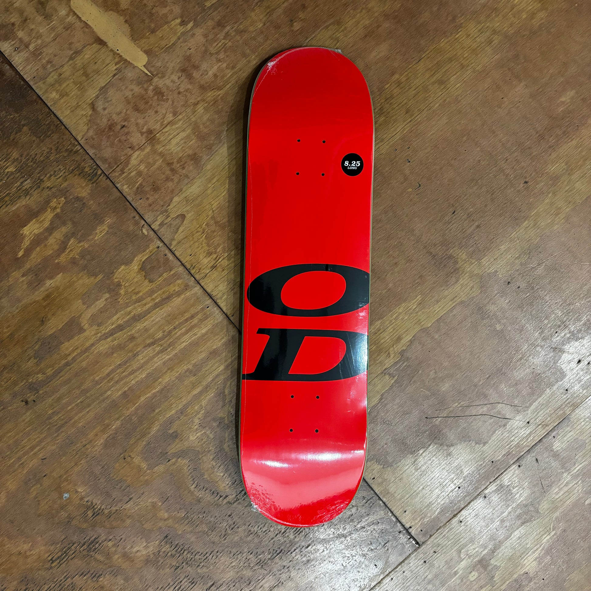 gloss red skateboard deck with a large OD near the bottom truck holes