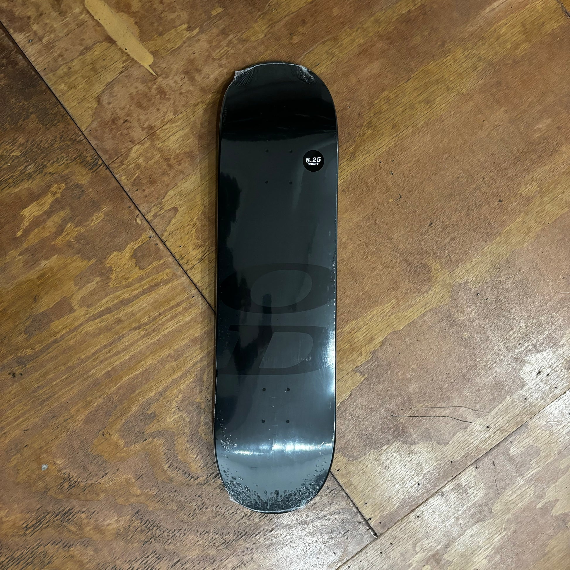 black full dipped skateboard deck with tonal OD printed near bottom truck holes