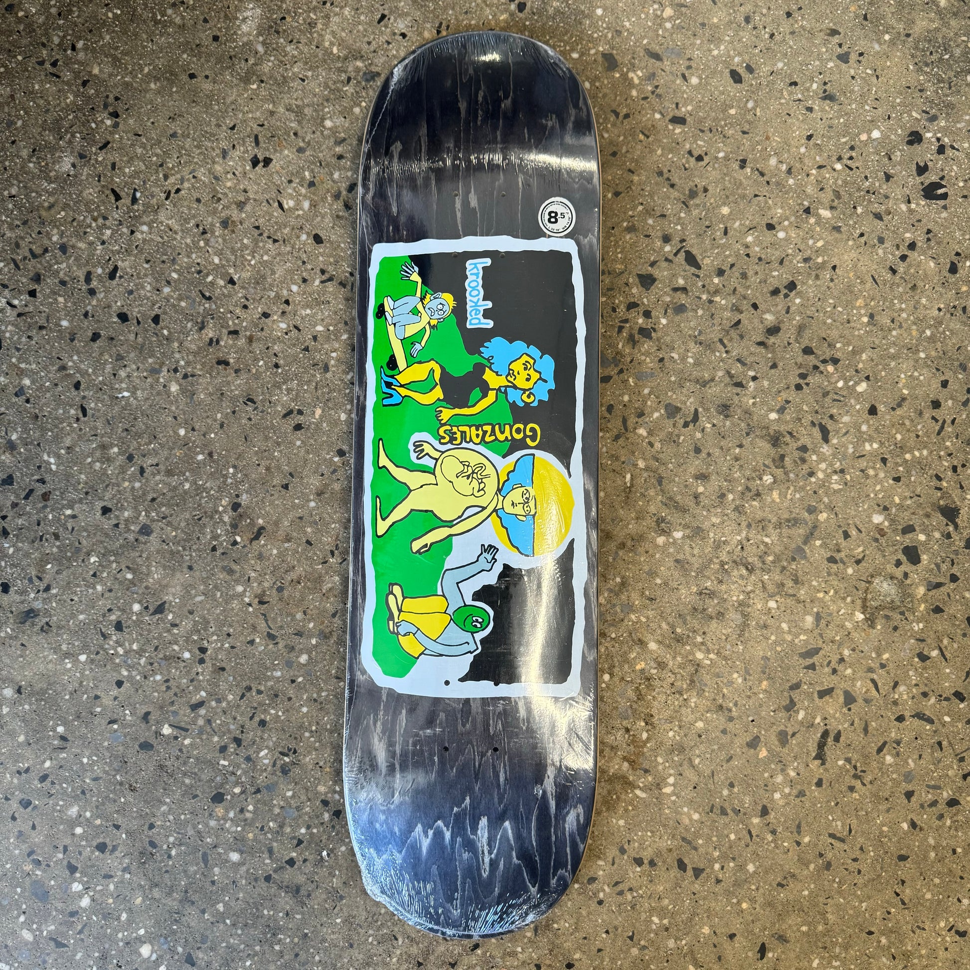 woodstained skateboard deck with illustrated figures walking across some grass