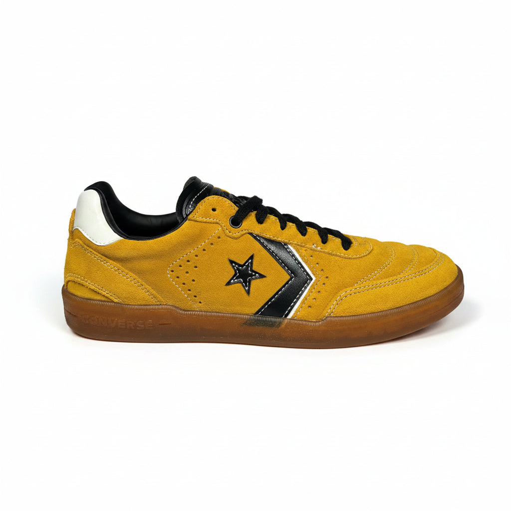 Yellow sneaker with black converse star logo on a white background